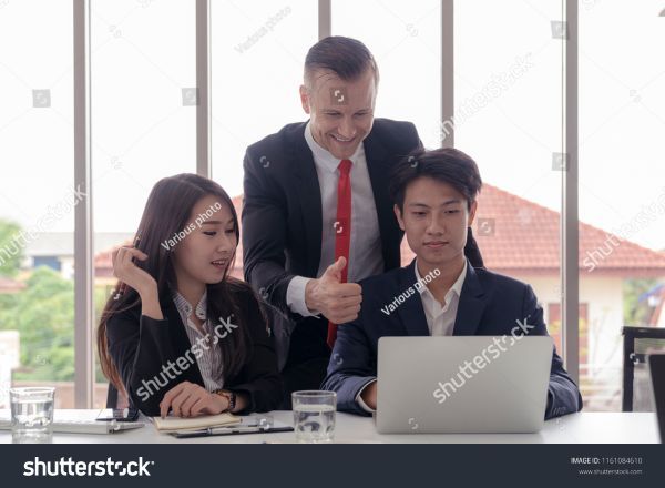 A manager approving work from two workers.