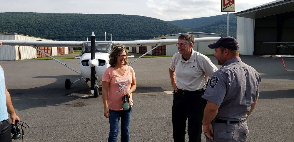 Billie, ret. Col. Hall and airport staff laugh as they prepare for the first lesson